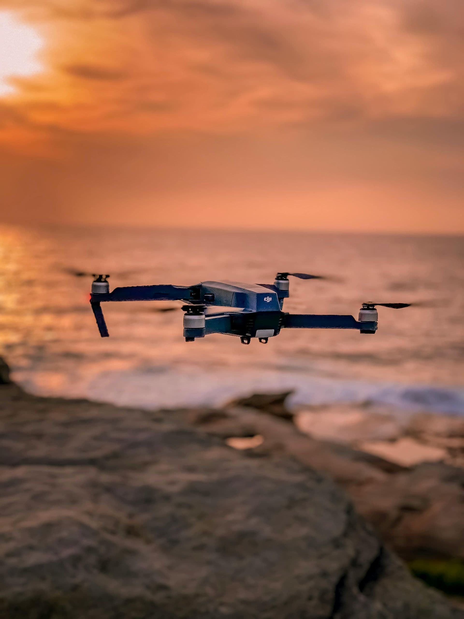 Drone flying over the ocean at sunset